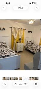 two beds in a room with yellow curtains at El rincón de Sánchez in Moca +17 photos