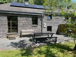 a picnic table in front of a brick building at Le Hérou in Houffalize