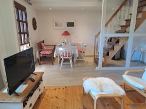 a living room with a tv and a dining room with a table at Ferienwohnung Rahn in Freienwill