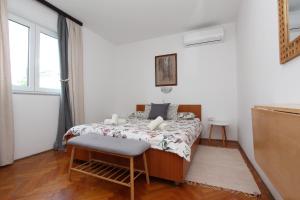 a bedroom with a bed with a chair and a window at Rooms and Studio Salvi in Rovinj
