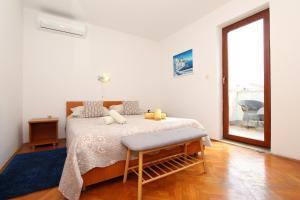 a bedroom with a bed with a chair and a window at Rooms and Studio Salvi in Rovinj