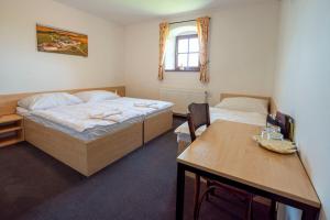 a bedroom with two beds and a desk and a table at Hospoda na sýpce in Kuks