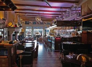 a restaurant with tables and chairs and a bar at hôtel Sube in Saint-Tropez