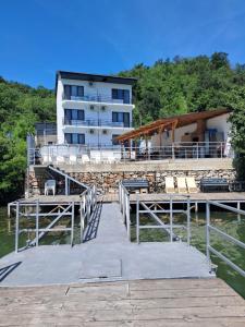 a dock in the water with a building in the background at Casa din Golful Dunării in Eşelniţa