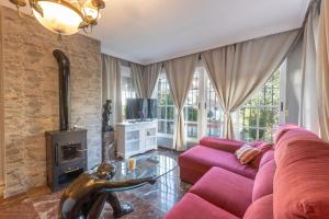 a living room with a pink couch and a fireplace at Cypress House La Zubia in La Zubia