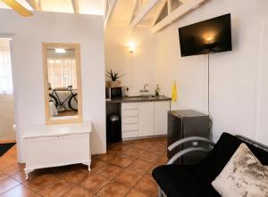 a living room with a couch and a kitchen at Zhantique Guest House 1- Unit 4 in Boksburg
