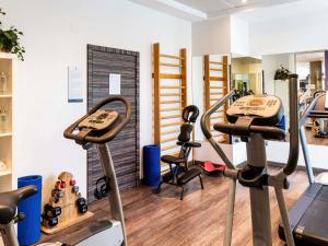 a gym with treadmills and ellipticals in a room at Novotel Suites Malaga Centro in Málaga