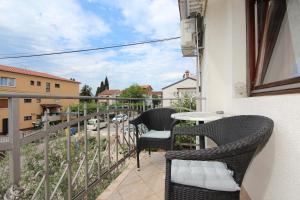 a balcony with two chairs and a table on a building at Rooms and Studio Salvi in Rovinj
