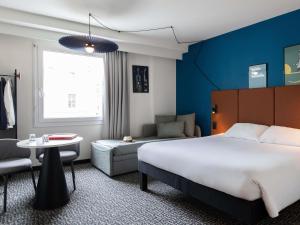 a hotel room with a bed and a chair and a table at ibis Lausanne Centre in Lausanne