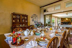 a dining room with a long table with dishes on it at Majorca House in Somerset West