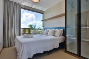 a bedroom with a bed and a large window at Condominio Frente Mar 3 suites com Ar Cond piscina e Hidro privativa in Mata de Sao Joao