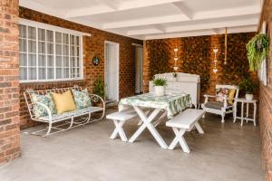 a patio with a table and chairs and a brick wall at Zhantique Guest House 1- Unit 4 in Boksburg