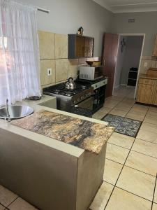 a kitchen with a sink and a stove top oven at Schilbach House in Parys