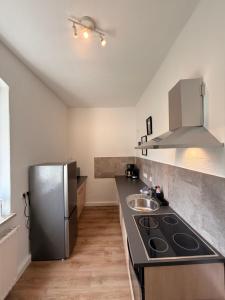 a kitchen with a stainless steel refrigerator and a sink at Stay&Work Döbeln - Hermsdorfer Straße in Döbeln