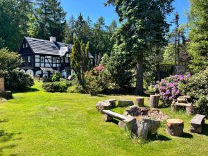 a house with a garden with logs in the yard at Hájenka Sněžník in Sněžnik