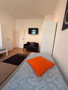a bedroom with a bed with an orange pillow on it at Stay&Work Döbeln - Hermsdorfer Straße in Döbeln