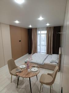 a bedroom with a bed and a table and chairs at ЖК Akjol in Astana