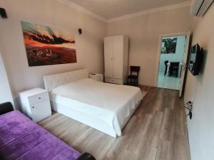 a bedroom with a white bed and a purple couch at Erme Dinlenme Tesisleri in Dernekpazarı