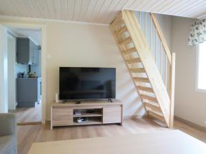a living room with a flat screen tv and a staircase at Higravstinden Basecamp - Lofoten in Laupstad