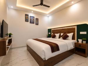a bedroom with a large bed and a flat screen tv at Guest House RK inn in Gorakhpur