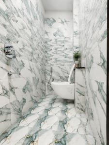 a bathroom with a white tub and marble walls at Guest House RK inn in Gorakhpur +8 photos
