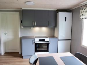a kitchen with white appliances and a table with chairs at Higravstinden Basecamp - Lofoten in Laupstad