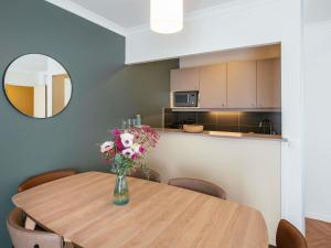 a dining room table with a vase of flowers on it at Aparthotel Adagio Paris Buttes Chaumont in Paris +67 photos