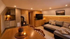 a living room with a couch and a table at Koča Rakitna Forest Chalet with Sauna in Preserje