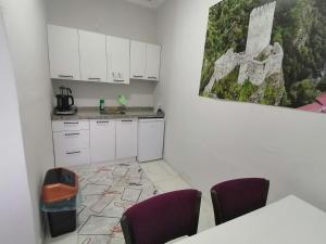 a kitchen with white cabinets and purple chairs at Erme Dinlenme Tesisleri in Dernekpazarı