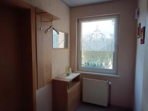 a bathroom with a window and a table and a radiator at Ferienwohnung Alte Post in Knorrendorf +15 photos