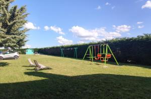a park with a playground with two chairs in the grass at L'Orée des Vignes 41 - Chambres d'hôtes in Saint-Georges-sur-Cher