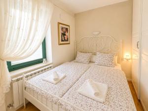 a bedroom with a white bed with two white towels at Apartment Sulle scale in Piran