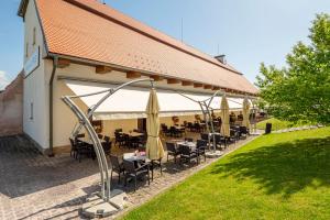 a restaurant with tables and umbrellas in front of a building at Hospoda na sýpce in Kuks