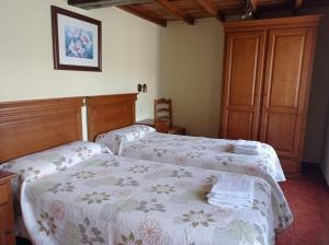 a bedroom with two beds with white and pink blankets at Romallande in Cabrafigal