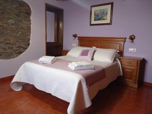 a bedroom with a bed with two towels on it at Romallande in Cabrafigal