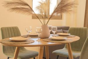 a wooden table with wine glasses and a vase at Central cozy studio in Agios Nikolaos