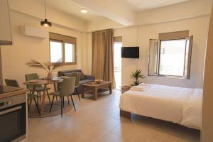 a bedroom with a bed and a table and a kitchen at Central cozy studio in Agios Nikolaos