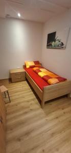 a bedroom with a bed in a room with wooden floors at Ferienwohnung zum Albuch in Nördlingen