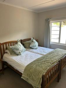 a bedroom with a bed with pillows and a window at 13 bedford street in Grahamstown
