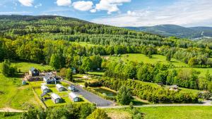 an aerial view of a farm with houses and trees at Domki Izerskie in Krobica