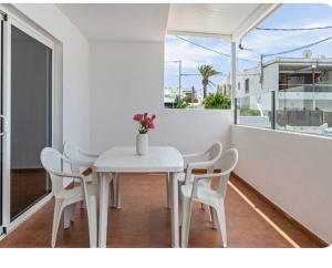a white dining room with a white table and chairs at Barlovento Apartment 2 in Playa Honda