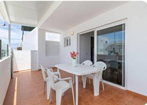 a white dining room with a white table and chairs at Barlovento Apartment 2 in Playa Honda