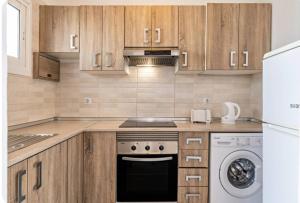 a kitchen with wooden cabinets and a stove and a dishwasher at Barlovento Apartment 2 in Playa Honda