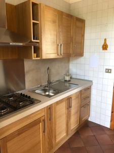a kitchen with wooden cabinets and a sink at Oasi Baia Verde in Baia Verde
