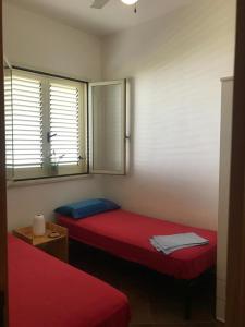 a room with two beds and a window at Oasi Baia Verde in Baia Verde