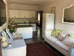a living room with a couch and a kitchen at 13 bedford street in Grahamstown