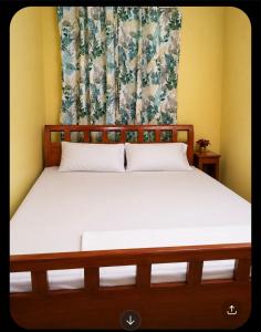 a bedroom with a large bed with a curtain at Welcome Home, whole 2 bedroom unit - VCDU Riverview, Mabini Plains in Mabini