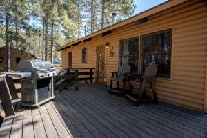 a cabin with a grill and a picnic table on a deck at Spacious Rustic Cabin with Vaulted Ceilings, Full Kitchen, Fireplace & Large Deck Near Babbitt, Minnesota in Babbitt