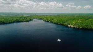 an aerial view of a boat in the middle of a river at Spacious Rustic Cabin with Vaulted Ceilings, Full Kitchen, Fireplace & Large Deck Near Babbitt, Minnesota in Babbitt