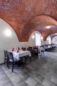 a dining room with tables and chairs and a brick wall at Hotel Salety in Valtice